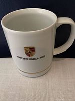 Front view showing Porsche crest, logo and gold band