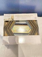 Boxed set of three hexagon mirrors showing frame color and shape