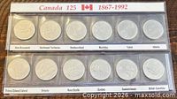 Full view of twelve-coin set in two plastic strips with Canada 125 header and province labels visible