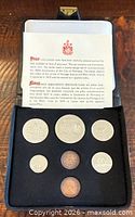 Open presentation case showing all seven coins and insert