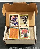 Open box showing three sample Bowman hockey cards on top of stacked cards