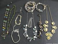 All nine jewellery items laid out on black background