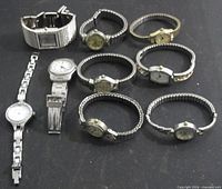 All nine watches laid out on black surface