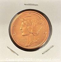 Obverse of copper round in holder showing Liberty with winged cap