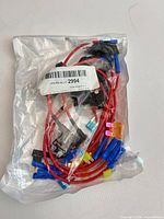 Sealed plastic bag containing multiple red-wired blade fuse tap pigtails with various connector colors