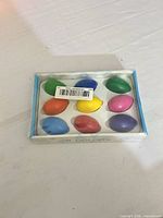 Top view of unopened package showing all nine egg-shaped crayons