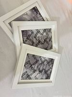 Three white picture frames stacked, front view