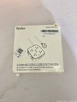 Front of damaged retail box showing Yintor branding and outlet/USB specifications