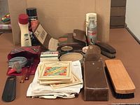 Group view of entire lot showing brushes, polishes, spray, bottle, leather case, plaid kit, cloths and paper cards