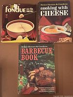 Front covers of all three hardcover cookbooks showing titles and condition including torn dust jacket on fondue book