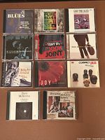 All 11 CD jewel cases front covers visible in a 3x4 grid layout