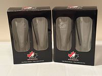 Two unopened retail boxes each containing two clear Hockey Canada pilsner glasses