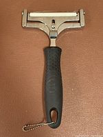 Front view of stainless cheese slicer showing blade and handle