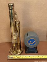 Both coin banks side by side with measuring tape for scale