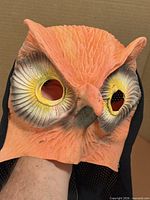 Front view of rubber owl mask showing eye openings and beak