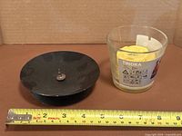 Metal candle holder next to IKEA Tindra glass candle with measuring tape for scale
