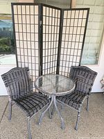 Bistro set with two wicker chairs, round glass table, folding privacy screen