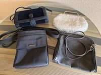 All four handbags displayed on glass table