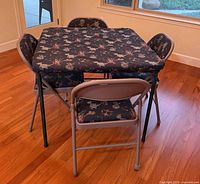 table and four chairs with golf print cover in room