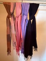 All four silk pashmina scarves hanging on rod showing colors and fringe