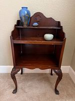 Full view of mahogany bedside table with pottery items displayed