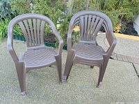 Two brown plastic patio chairs front view