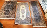 All three rugs laid out showing designs and fringe