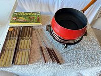 Full view of fondue pot on stand, forks, cookbook