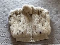Front view of cream fox fur vest showing snap-button closure and leather waistband