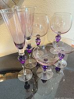 Full six-piece glassware set showing flutes, goblets and coupes with purple stems