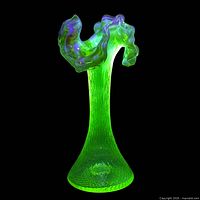 Vase glowing bright green under UV showing uranium content and ruffled rim shape