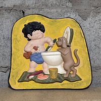 Front view of painted plaster plaque depicting boy and dog scene