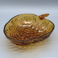 Top view of amber pressed glass bowl showing grape cluster design and leaf handle