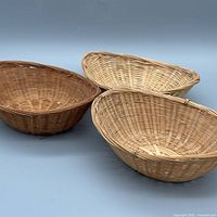 Three woven wicker baskets grouped to show size and color variation