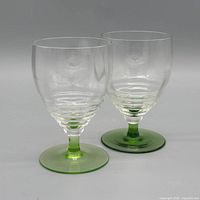 Front view of both goblets displaying clear bowls and green bases