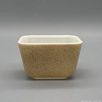 Front view showing beige speckled exterior of glass dish