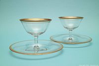 Two sherbet coupes on matching saucers showing size and gold trim