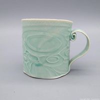 Side view showing glaze color, carved pattern, handle detail