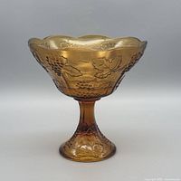 Full view of amber pedestal compote showing grape pattern