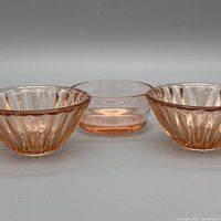 Three pink pressed glass dessert bowls, two fluted and one plain, group shot