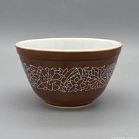 Front view of brown Pyrex Woodland bowl with white floral motif