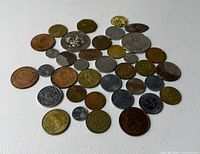 Overview of approximately 35 coins and tokens spread on table