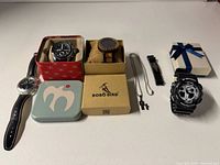 Group of four watches, necklace, spare band, boxes