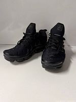 Three-quarter front view of both sneakers showing uppers and soles