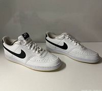 Side view of both shoes showing Nike Swoosh and overall condition