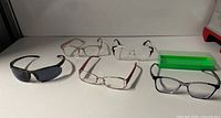 All five pairs of glasses arranged with green case