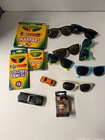 Entire lot showing sunglasses, Crayola supplies, toy cars, Funko figure