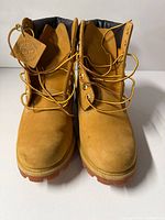 Front view of pair of Timberland wheat boots showing laces, tag, padded collars