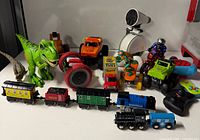 Full view of assorted toys: dinosaurs, vehicles, train pieces, telescope, yo-yo