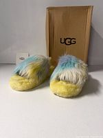Front view of slippers showing tie-dye shearling and box